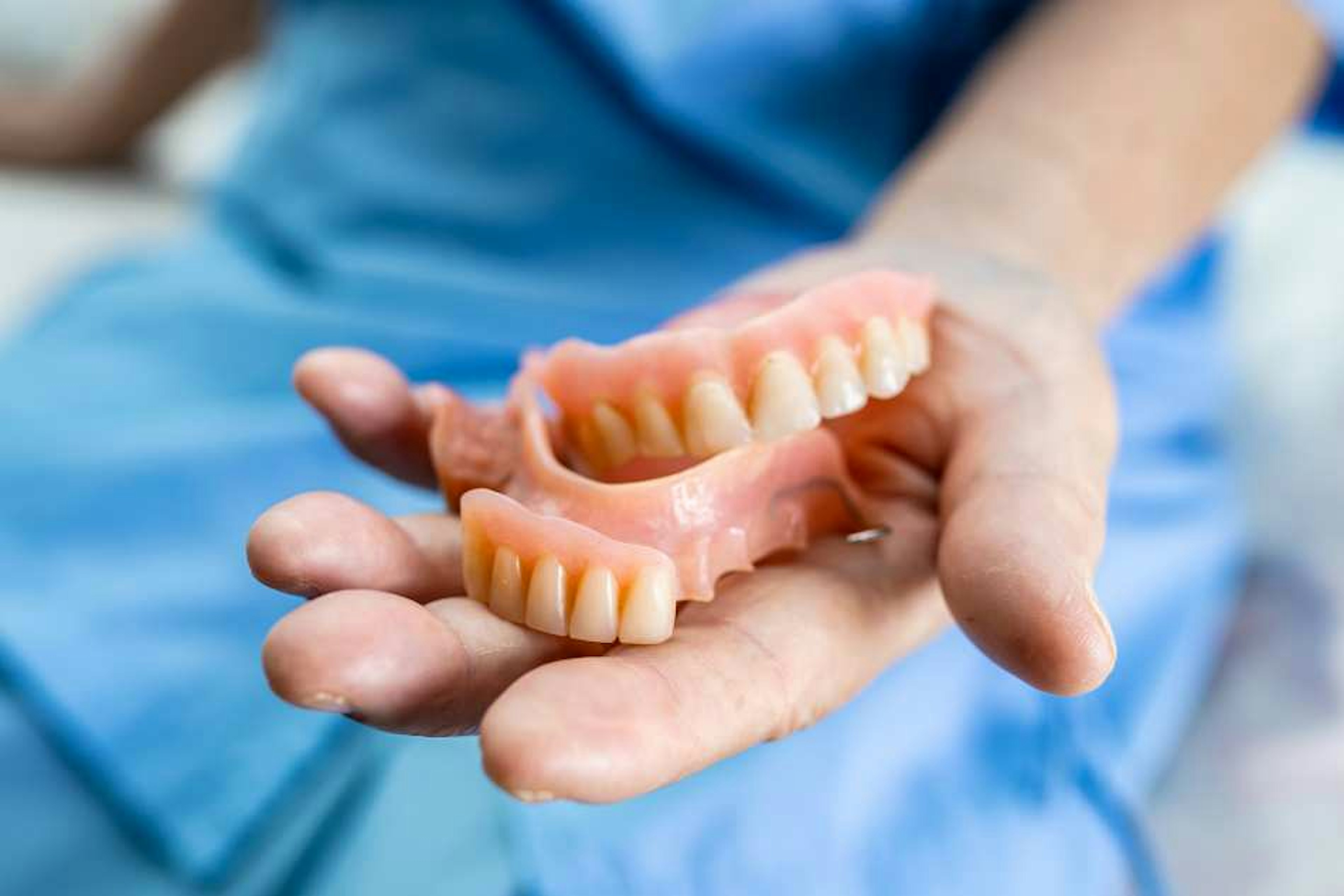 Professional prosthetist examining dentures for repair needs